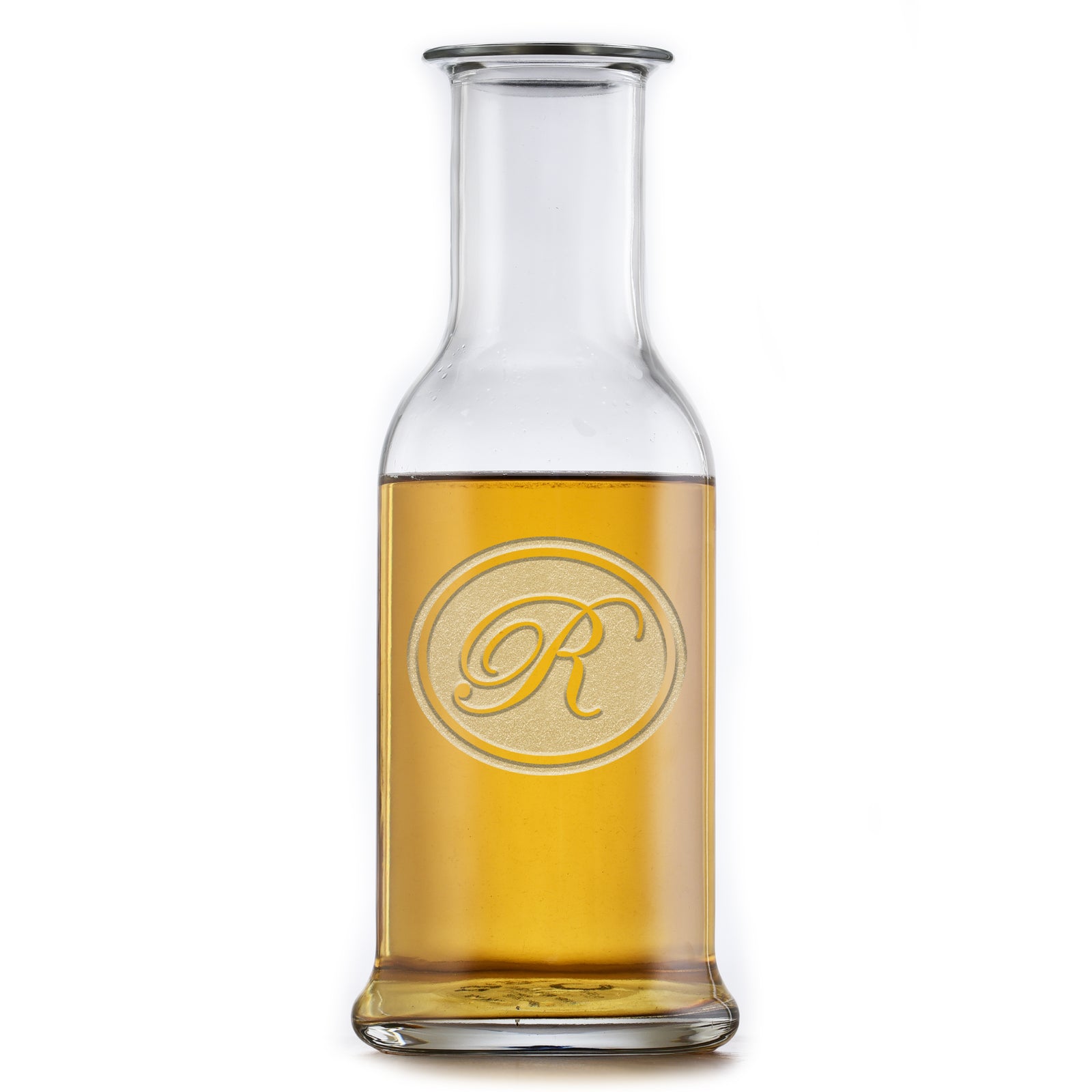 Round-shoulder wine carafe deep-carved with a script initial inside a thin circle, filled with a golden drink, on a white background.