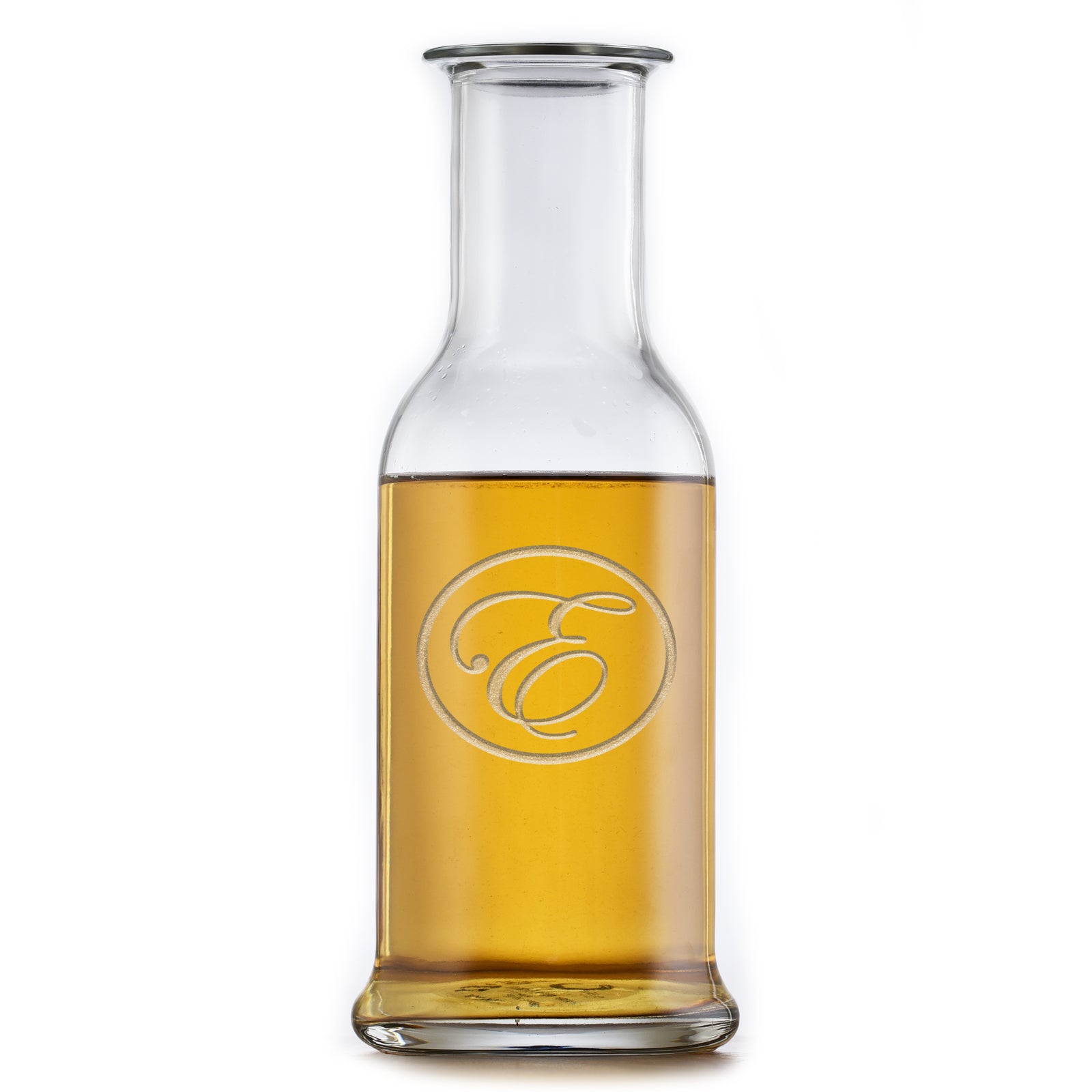 Round-shoulder wine carafe deep-carved with a script initial inside a thin circle, filled with a golden drink, on a white background.