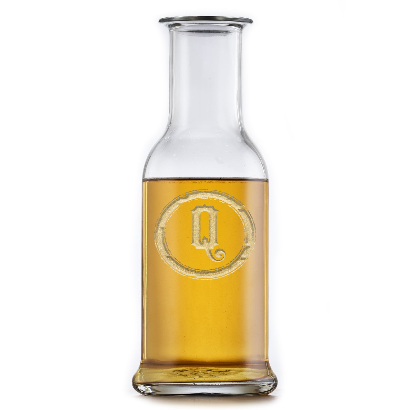 Round-shoulder wine carafe deep-carved with a block-letter initial inside a barbed circle, filled with a golden drink, on a white background.